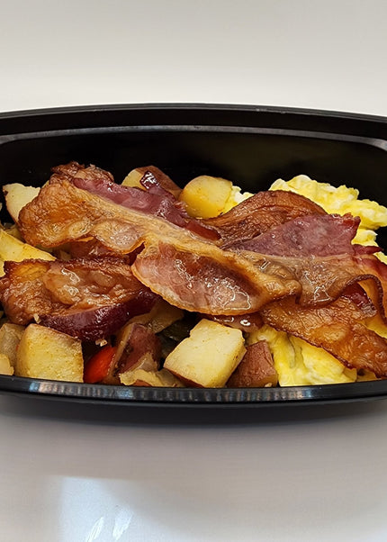 Scrambled eggs with melted cheese and crispy bacon in a black meal prep container in Denton Texas