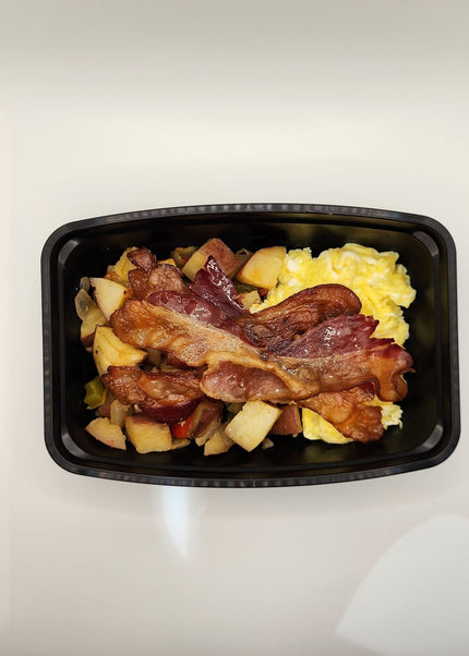 Scrambled eggs with melted cheese and crispy bacon in a black meal prep container in Denton Texas