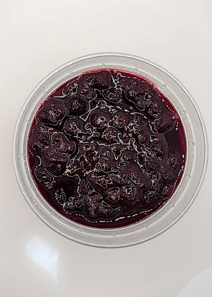 Oatmeal topped with mixed berry compote in a clear container