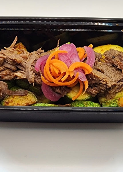 Shredded beef barbacoa with rich seasoning in a Chef Shaby meal prep container