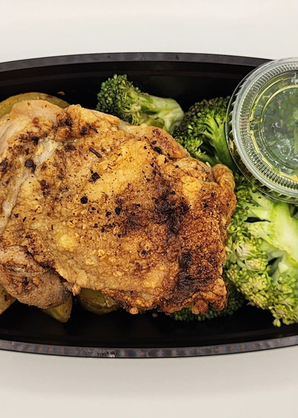 Chicken thigh topped with chimichurri sauce in a meal prep tray