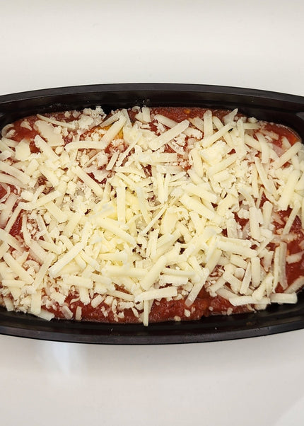 Slice of beef lasagna with cheese layers in a Chef Shaby meal prep container