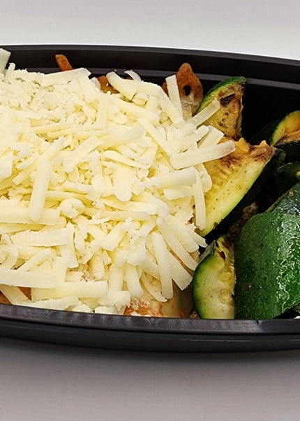 Slice of beef lasagna with cheese layers in a Chef Shaby meal prep container