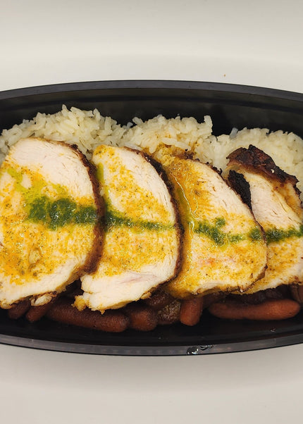 Sliced roasted chicken breast with rice and vegetables in a meal prep container