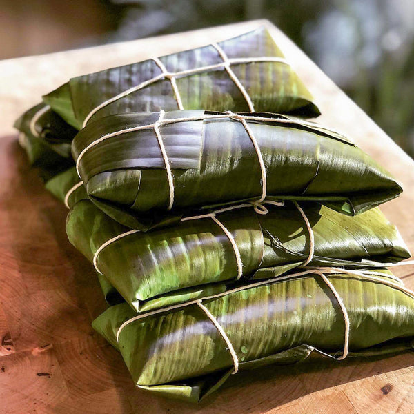 “Traditional Puerto Rican pasteles wrapped in banana leaves handmade weekly by Chef Shaby y Su Mai”